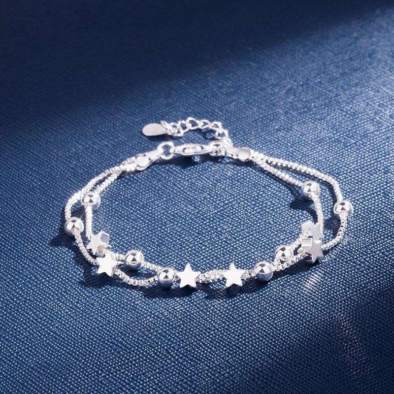 Silver Pentagram Star Bracelet displayed on a blue background, featuring stars and beads in a detailed design.